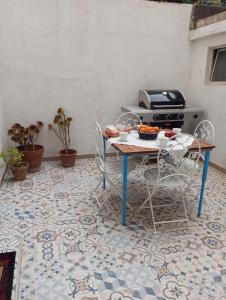 une terrasse avec une table, des chaises et une cuisinière dans l'établissement Les Portes Blaves, à Alghero