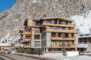 un bâtiment en face d'une montagne dans l'établissement Appartement Sifflote - LES CHALETS COVAREL, à La Daille