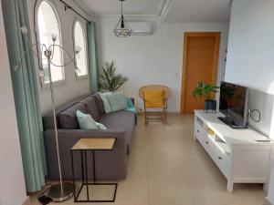a living room with a couch and a tv at La Casa Mima Penthouse at Hacienda Riquelme in Sucina
