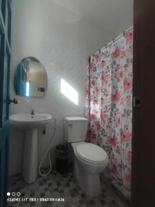 a bathroom with a white toilet and a sink at Tanyon Bay Beach House in Ronda