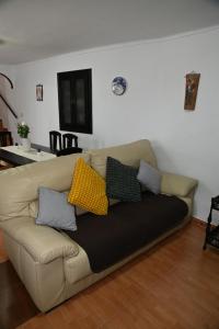 a couch with pillows on it in a living room at Casita Ladera, Setenil - Cádiz in Setenil