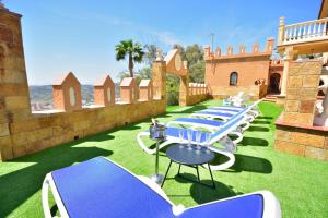a row of blue and white tables on the grass at Villa rural en Málaga con piscina y vistas al mar in Málaga