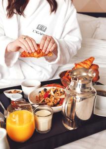 a woman holding a plate of food on a tray at L'Agapa Hôtel - Spa Codage in Perros-Guirec