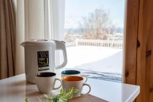 two cups of coffee sitting on a table next to a window at The Crestview Lodge 