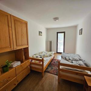 - une chambre avec 2 lits et des placards en bois dans l'établissement Adventure Farm, à Štore