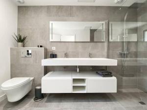 a bathroom with a white sink and a toilet at Villa La Foret Du Lac à HOSSEGOR in Soorts-Hossegor +19 photos