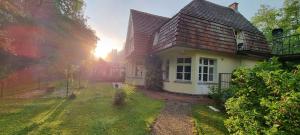 una pequeña casa blanca con el sol en el fondo en Villa Lebensraum Bahnhoftraum, en Braunfels