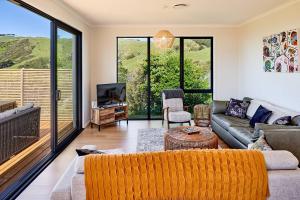 a living room with a couch and a tv at Tranquility on the Hill Outdoor Bath 30 mins to city by train or car in Wellington