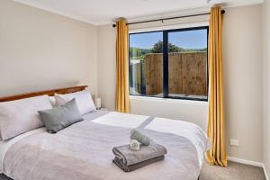 a bedroom with a bed with a large window at Tranquility on the Hill Outdoor Bath 30 mins to city by train or car in Wellington
