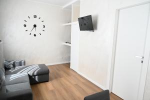 a room with a couch and a clock on the wall at Perla Marina 2 Acitrezza in Acitrezza
