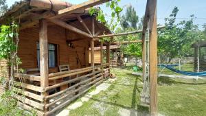 um chalé de madeira com uma rede de descanso no exterior em Tiny houses Genacvale em Martvili