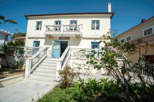 une maison blanche avec des escaliers et un balcon. dans l'établissement Hotel Argo, à Galaxidi