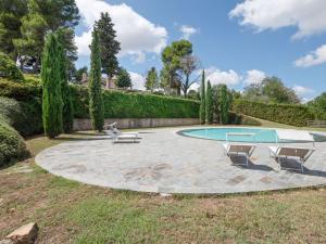 une terrasse avec une piscine et deux chaises dans l'établissement Stunning Apartment in Mombaroccio near Metauro River, à Mombaroccio
