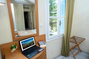 un ordinateur portable assis sur un bureau à côté d'une fenêtre dans l'établissement Hotel Argo, à Galaxidi