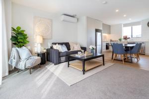 Relaxing City Hideaway - 2 Bed in Christchurch CBD في كرايستشيرش: غرفة معيشة بها أريكة وطاولة