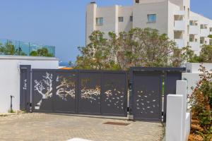 a black gate with a mural of a tree on it at Fig Tree Bay Residences 4 in Protaras