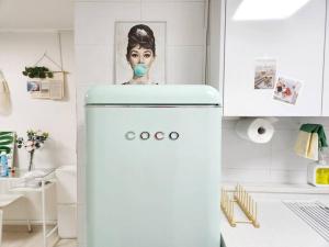 a refrigerator in a kitchen with a picture of a woman at Near Mangwon Market, 5mins to Hongdae Station by car in Seoul