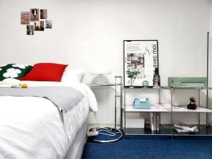 - une chambre avec un lit blanc et un tapis bleu dans l'établissement Near Mangwon Market, 5mins to Hongdae Station by car, à Séoul