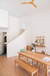 ein Esszimmer mit einem Tisch und einer Treppe in der Unterkunft Jeju Green Stay Nuguhana in Jeju-do