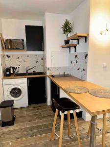 cocina con mesa y lavadora en Appartement Neuf confort, en Écully