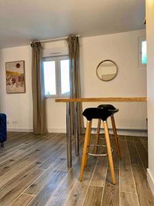 taburete en una habitación con mesa y espejo en Appartement Neuf confort, en Écully