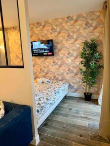 Habitación con TV en la pared en Appartement Neuf confort, en Écully