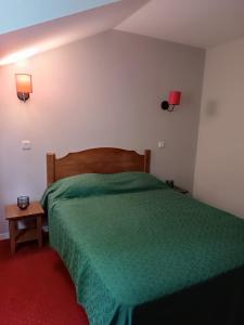um quarto com uma cama verde e um tapete vermelho em Petite maison dans Résidence em Monflanquin