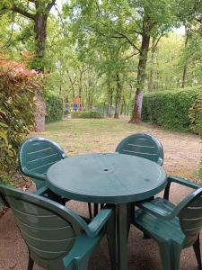 una mesa y sillas con un parque infantil en el fondo en Petite maison dans Résidence, en Monflanquin