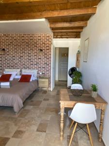 a bedroom with a bed and a brick wall at Très beau studio avec terrasse in Zonza
