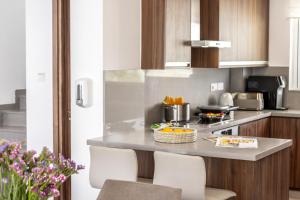 a kitchen with a counter with a table and chairs at Fig Tree Bay Residences 4 in Protaras +105 photos