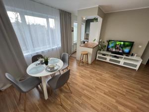 a living room with a table and chairs and a television at Tallinn Panorama Apartment Majaka in Tallinn