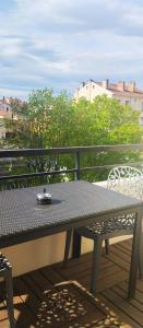 une table et des chaises assises sur un balcon dans l'établissement Chambre 20 m2 S de B WC privés Terrasse Garage, à Lyon