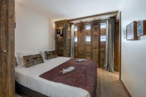 a bedroom with a large white bed and a window at Appartement Fusée - LES CHALETS COVAREL in Le Joseray