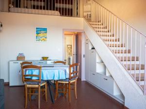 un comedor con mesa y sillas y una escalera en Appartement de charme avec vue mer époustouflante, en Hyères