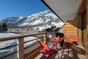 a table and chairs on a balcony with a mountain at Appartement Fusée - LES CHALETS COVAREL in Le Joseray