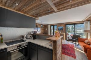 a kitchen with a counter and a living room at Appartement Fusée - LES CHALETS COVAREL in Le Joseray