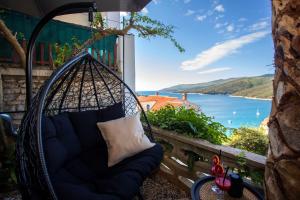 a porch swing with a view of the water at Studio Apartment Mia in Rabac