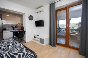 a bedroom with a bed and a kitchen with a balcony at Studio Apartment Mia in Rabac