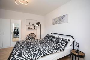 una camera da letto con un letto con un piumone bianco e nero di Studio Apartment Mia a Rabac