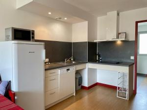 a small kitchen with a sink and a refrigerator at MEHATCHE Piscine Vue Montagnes in Souraïde