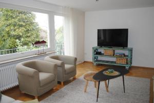 sala de estar con 2 sillas y TV de pantalla plana en Ferienhaus Joos, en Uhldingen-Mühlhofen