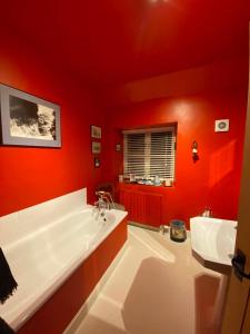 a red bathroom with a tub and a sink at Market Place Cottage, Tetbury, Cotswolds Grade II Central location in Tetbury
