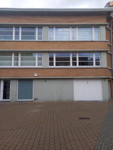 a building with two white garage doors on it at The Loft 2.0 in De Panne
