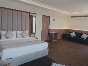 una camera d'albergo con un grande letto e un divano di Cilantro Comfort Jaipur a Jaipur