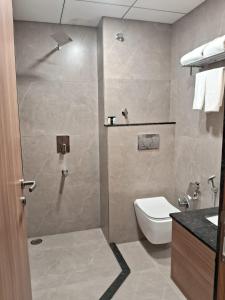 a bathroom with a shower with a toilet and a sink at Cilantro Comfort Jaipur in Jaipur