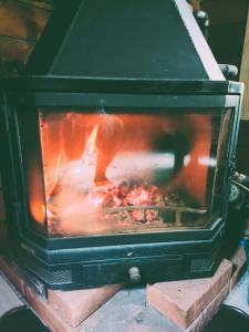 a stove with a fire inside of it at Chata pri 7 jazerách s vyvýšenou terasou in Štiavnické Bane