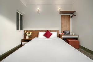 1 dormitorio con 1 cama blanca grande con almohadas rojas en Khách Sạn Nami Nha Trang, en Nha Trang