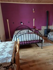 a bedroom with a bed and a purple wall at viesu nams "Laimes pakavs" in Straupe