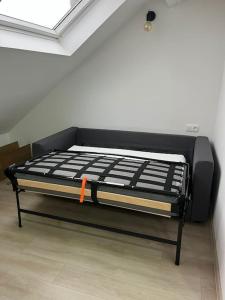 Una cama negra con una etiqueta naranja. en The Cosy House, en Bruselas
