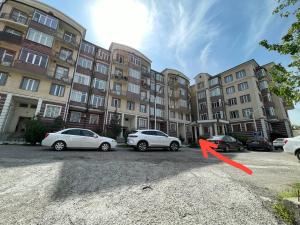 een groep auto's geparkeerd op een parkeerplaats voor gebouwen bij OS Rill in Samarkand